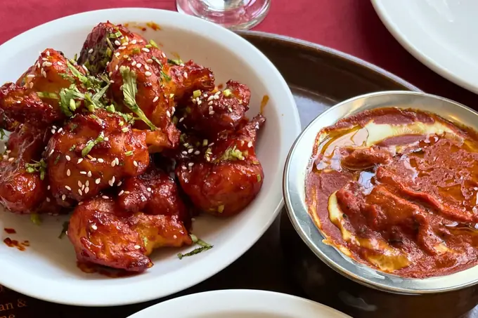 Chilli chicken and a bowl of butter chicken photographed close up at Delhi Palace