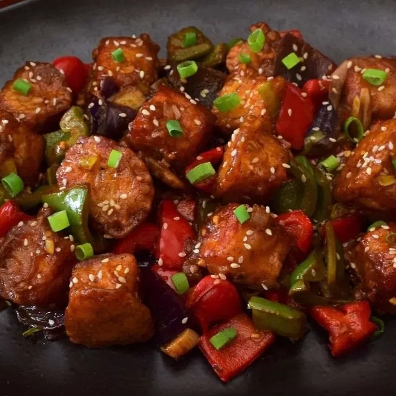 Chilli paneer dry served on a black platter