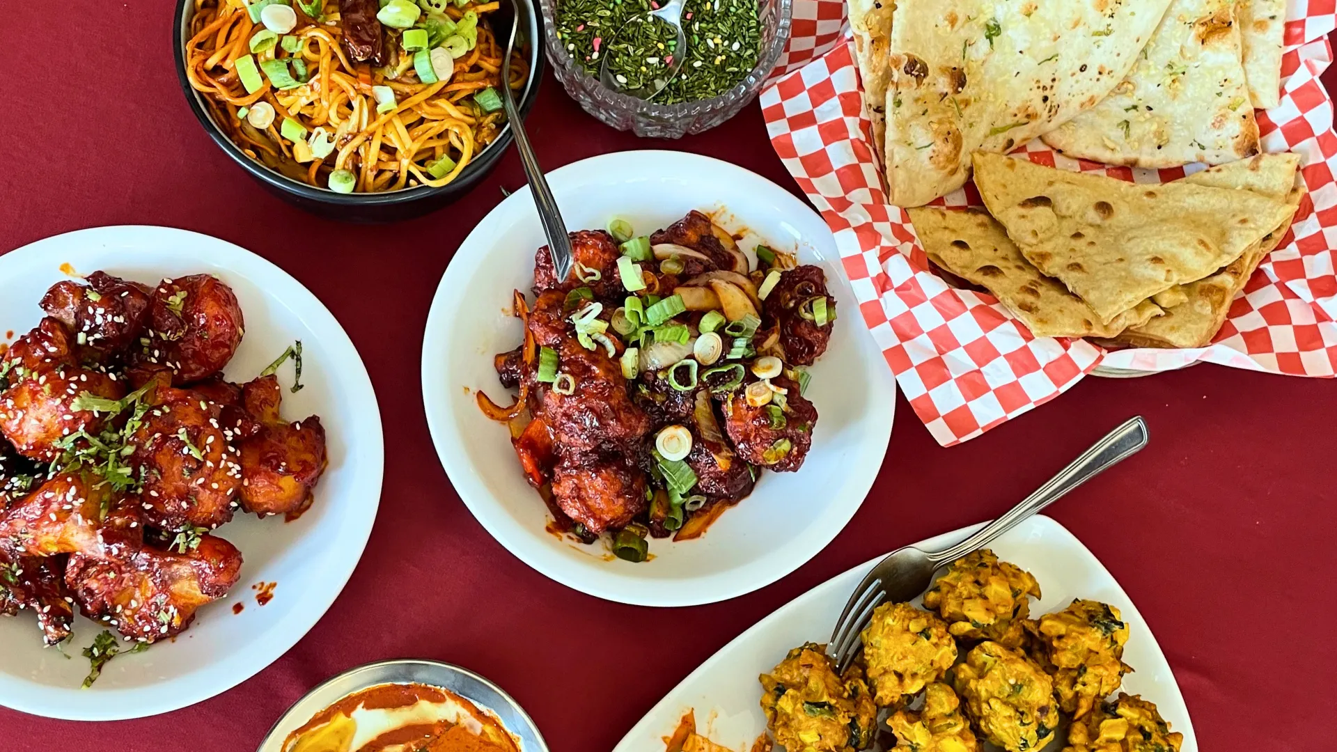A takeout-ready spread of Hakka noodles, chilli chicken, pakora and naan at Delhi Palace Brantford