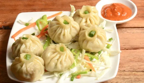 Hand folded steamed momos with chilli sauce at Delhi Palace Brantford