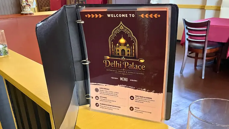 The welcome menu binder standing on a table inside Delhi Palace