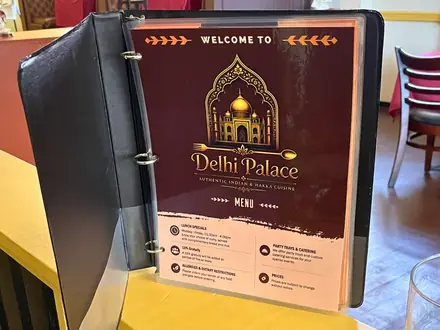 The welcome menu binder standing on a table inside Delhi Palace